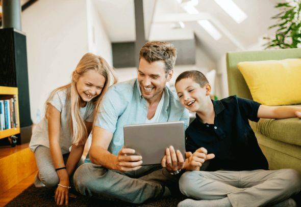 Young family looking at a digital tablet and smiling
