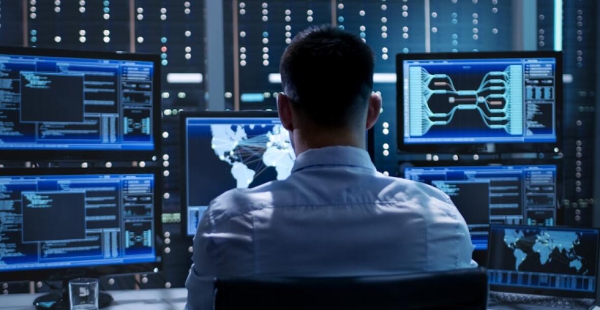 Man looking at multiple computer screens