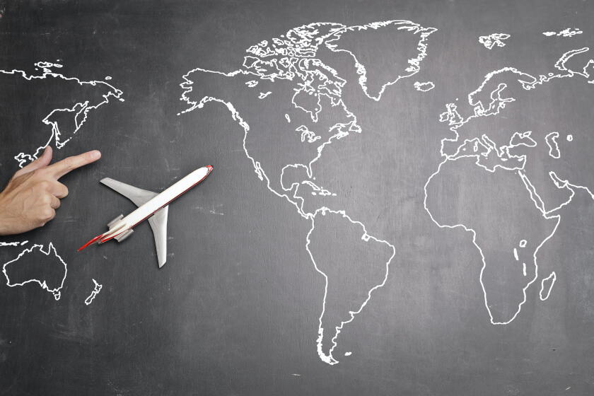 World map with a model plane in the Pacific Ocean space.