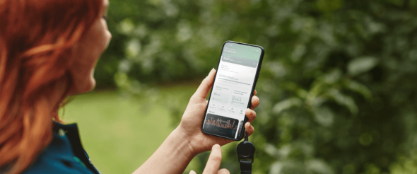 Person smiling while using the My One NZ app on their mobile phone.