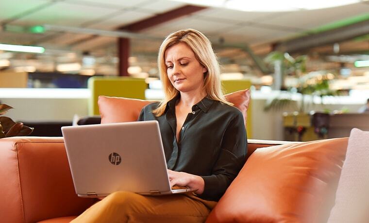 Woman sitting on couch with laptop in her lap