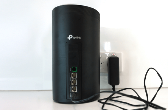 TP-Link modem with highlighted power adapter and ports.