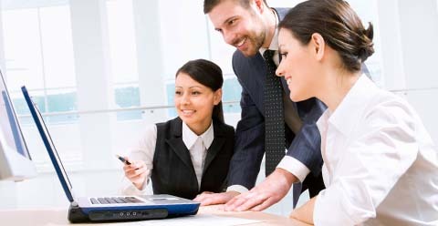 Trio of business people discussing sales strategy with laptop