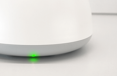 Bottom part of Deco BE28 modem with a green LED light