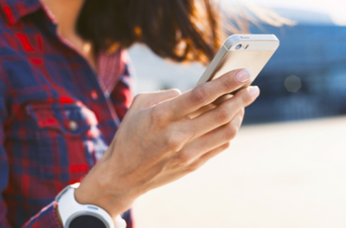 girl with red checkered shirt typing on her phone