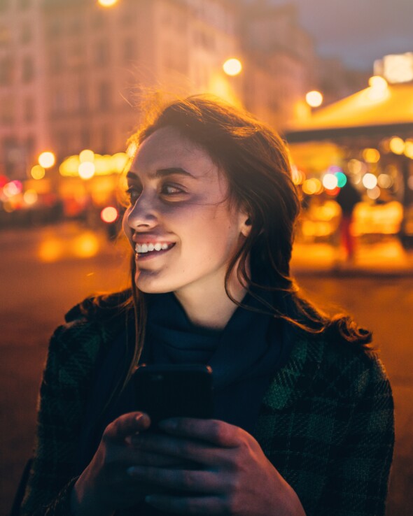 A happy traveler enjoying the night in downtown Auckland city.