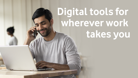Man using his laptop and talking on phone in his home office.