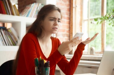 Lady in an office looking at her mobile phone