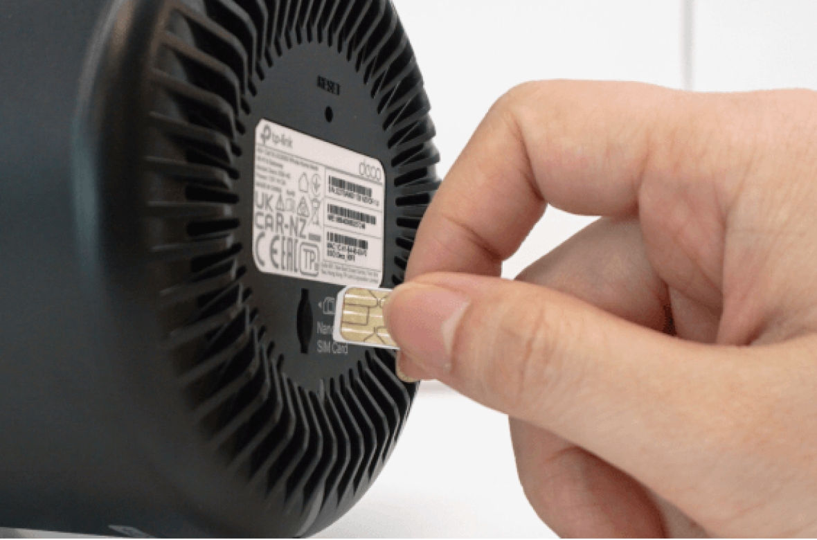Person inserting SIM card at the bottom of Deco X58-4G modem