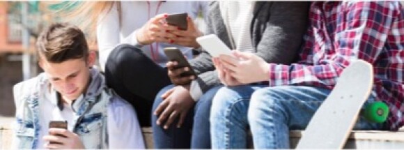 Group of teenagers sitting together using their mobile phones.