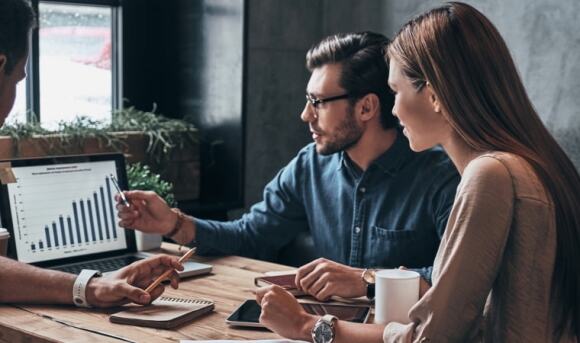 Team reviewing charts on laptop in an office