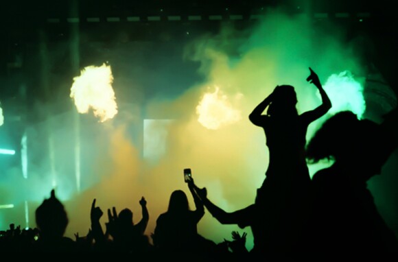 A silhouette of fans holding up cameras at a concert.