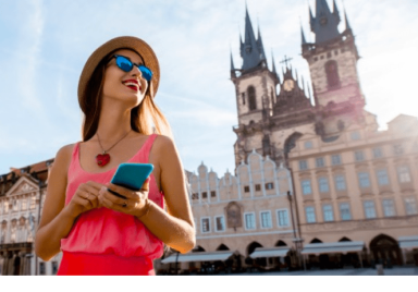 Girl using phone in front of church of our lady, prague