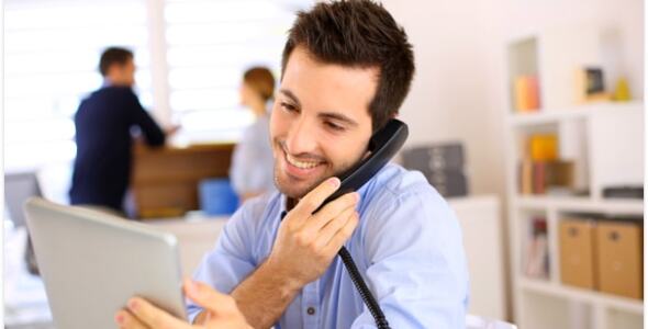 Guy on a call in the office viewing content on tablet