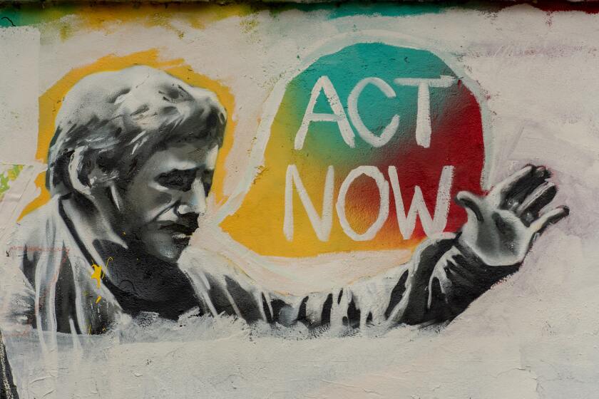 A graffiti wall featuring a greyscale man with a tri-colour speech bubble saying "ACT NOW" | Photo by Rod Long on Unsplash