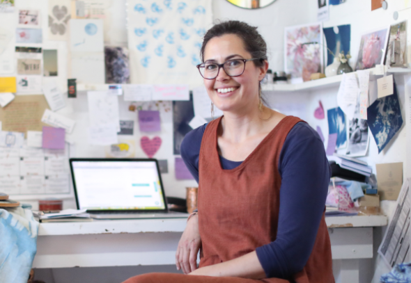 A lady running her small business, at a desk with her laptop.