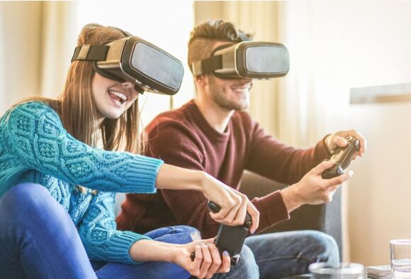 Two people paying a game wearing VR headsets.