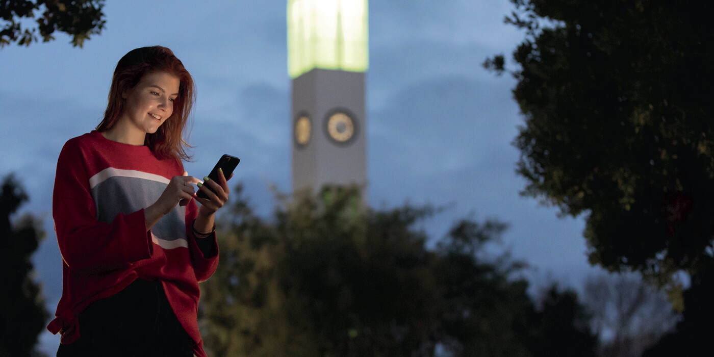 A smiling lady, checking her phone in Manawatu.