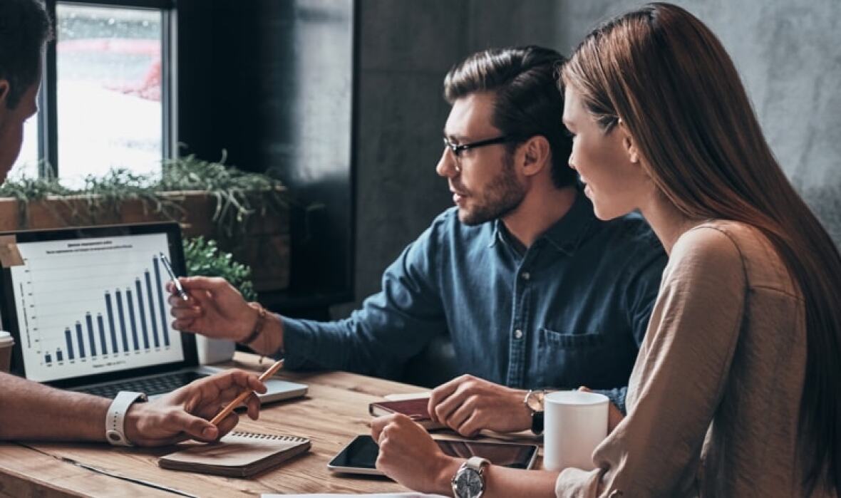 Team reviewing charts on laptop in an office