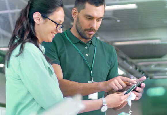 A shop employee helping a woman with the recycle process.