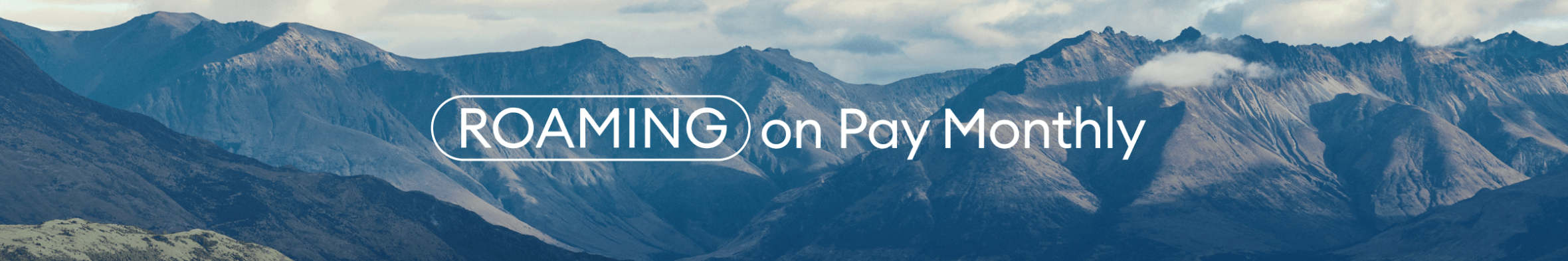 Scenic mountain range with “ROAMING on Pay Monthly” text overlay against a dramatic cloudy sky.