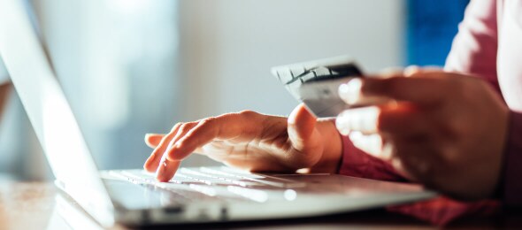 Person typing credit card details on a laptop