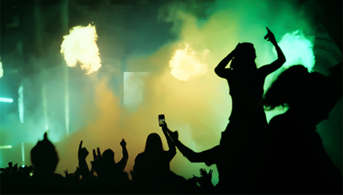 People dancing in a concert holding their phones.