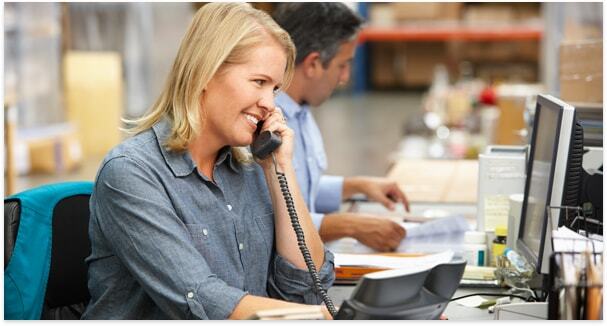 Lady smiling on a phone call to customer in a sales office