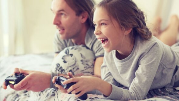 Father and daughter playing a video game together.
