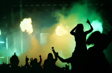 A silhouette of fans holding up cameras at a concert.