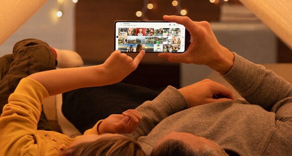 Two people looking at photos on a Galaxy phone.