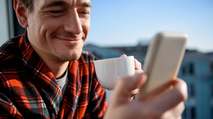 A smiling man, checking his usage on the My One NZ app.